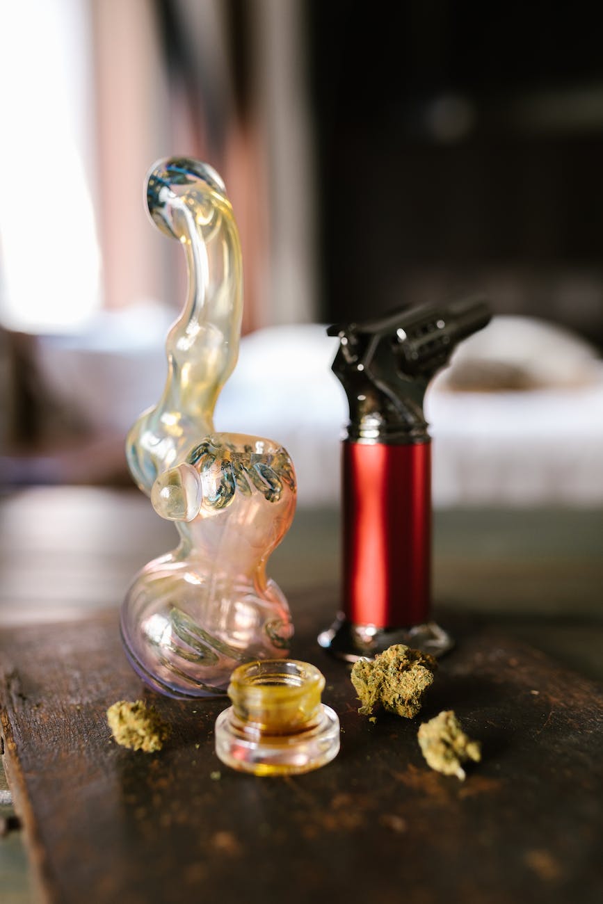 clear glass water bong on brown wooden table
